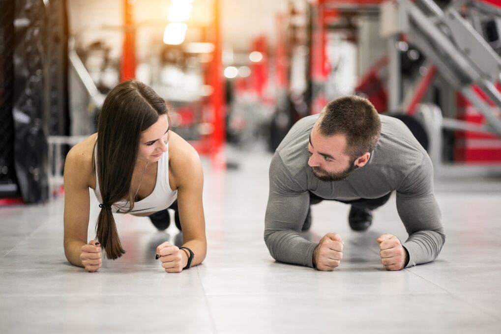Një burrë dhe një grua kryejnë ushtrimin Plank, i krijuar për të gjitha grupet e muskujve